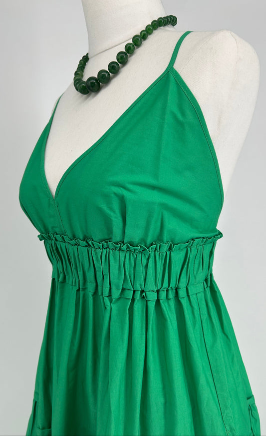 Green dress on a mannequin with a plain background