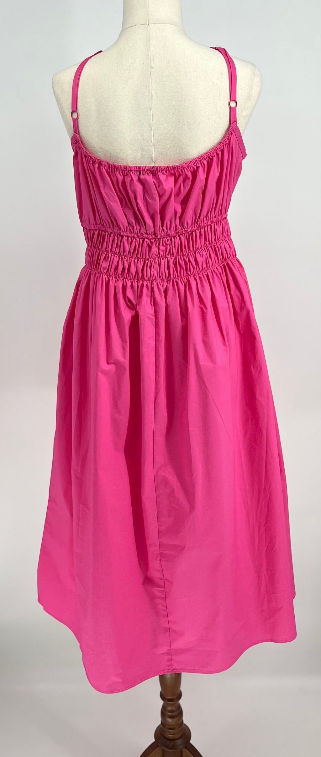 Pink dress on a mannequin against a white background