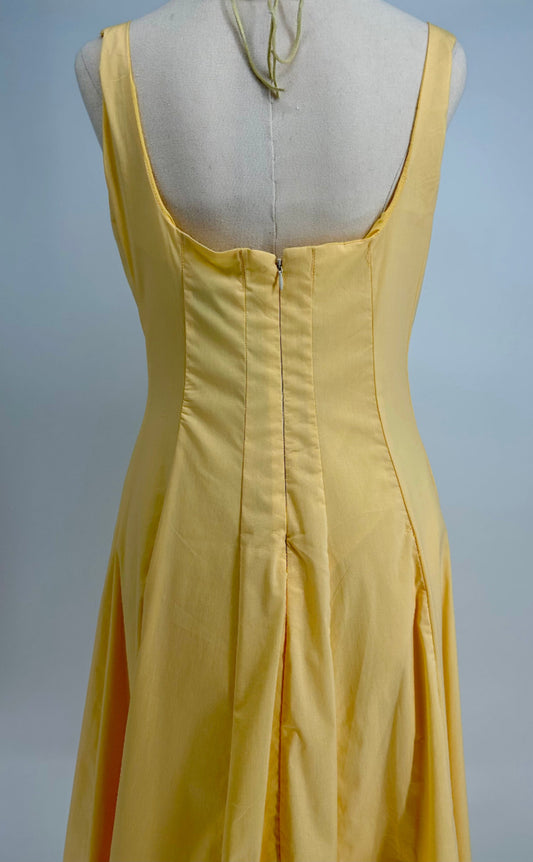 Yellow dress on a mannequin against a gray background