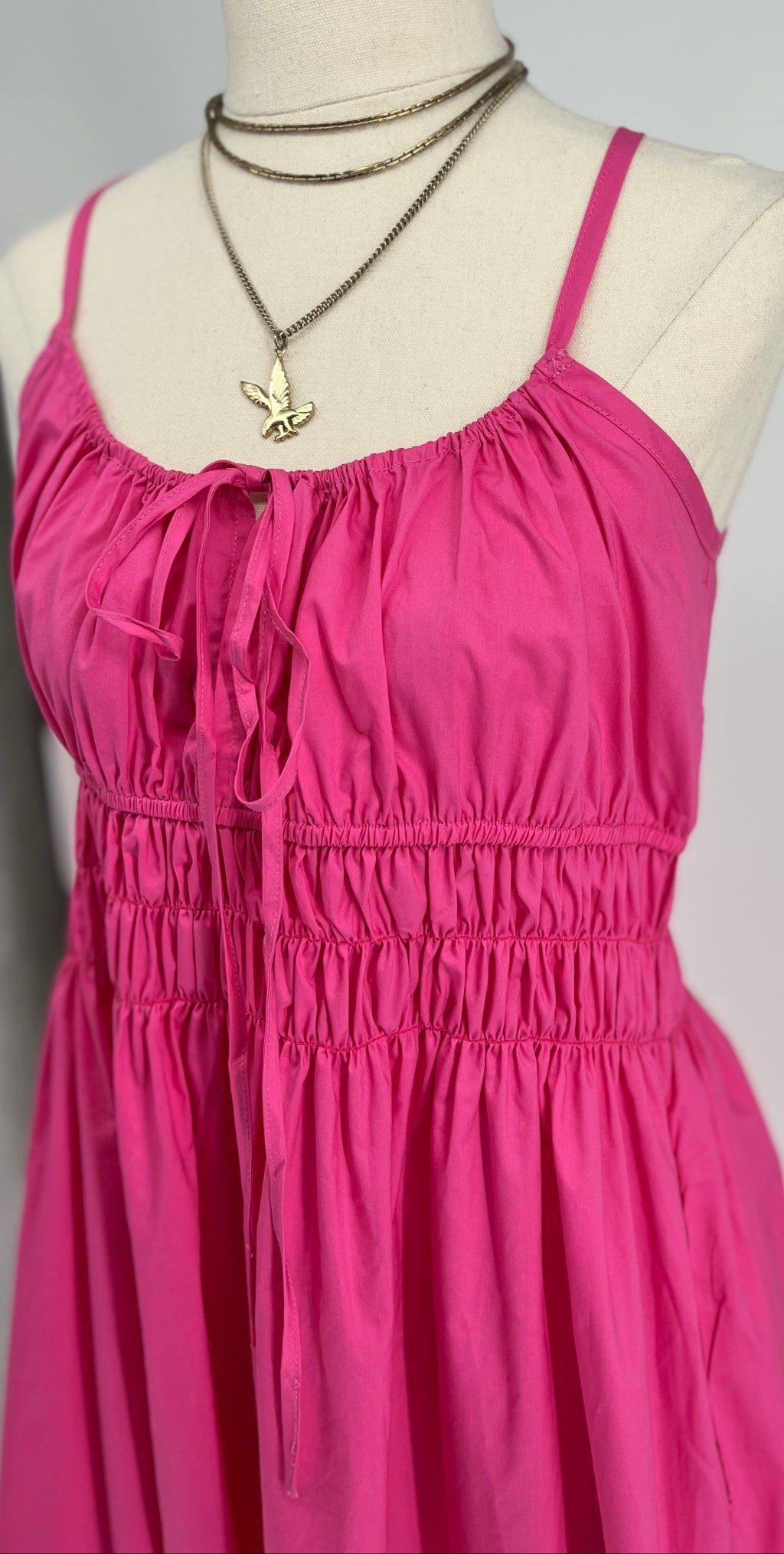 Pink dress on a mannequin with a grey background