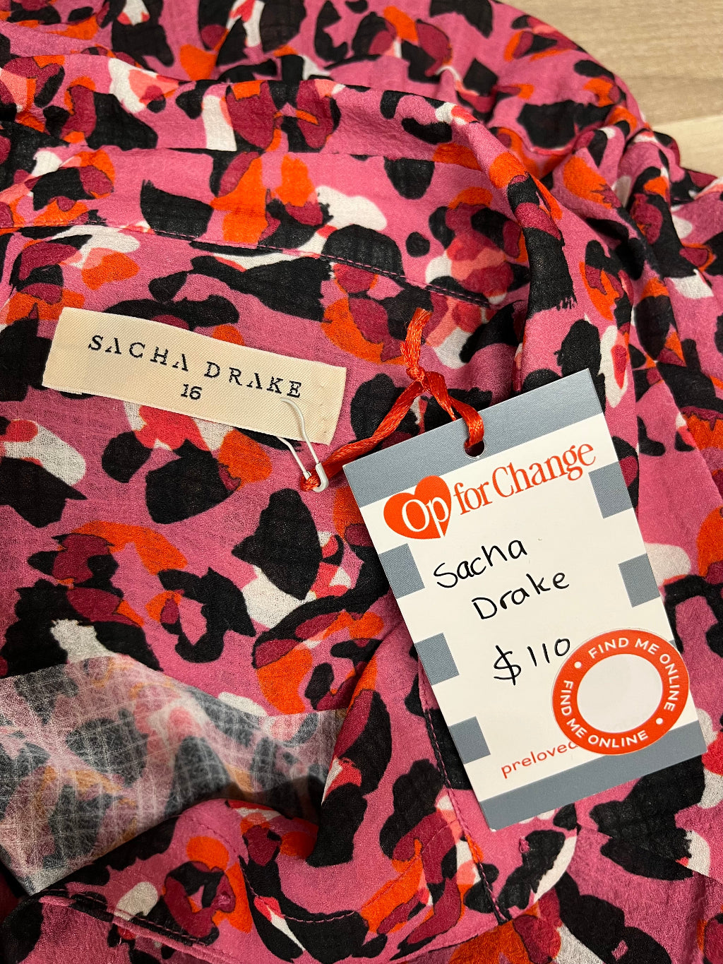 Pink fabric with black and orange pattern, featuring a Sacha Drake tag and Op for Change preloved label.