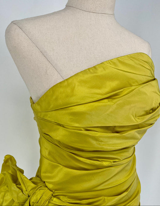 Yellow strapless dress on a mannequin against a plain background
