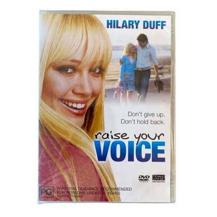 DVD cover for the movie 'Raise Your Voice' starring Hilary Duff, featuring a close-up of a smiling Hilary on the left and a couple walking on a beach in the background on the right.