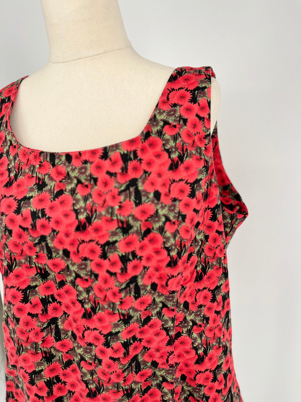 Red floral dress on a mannequin against a white background
