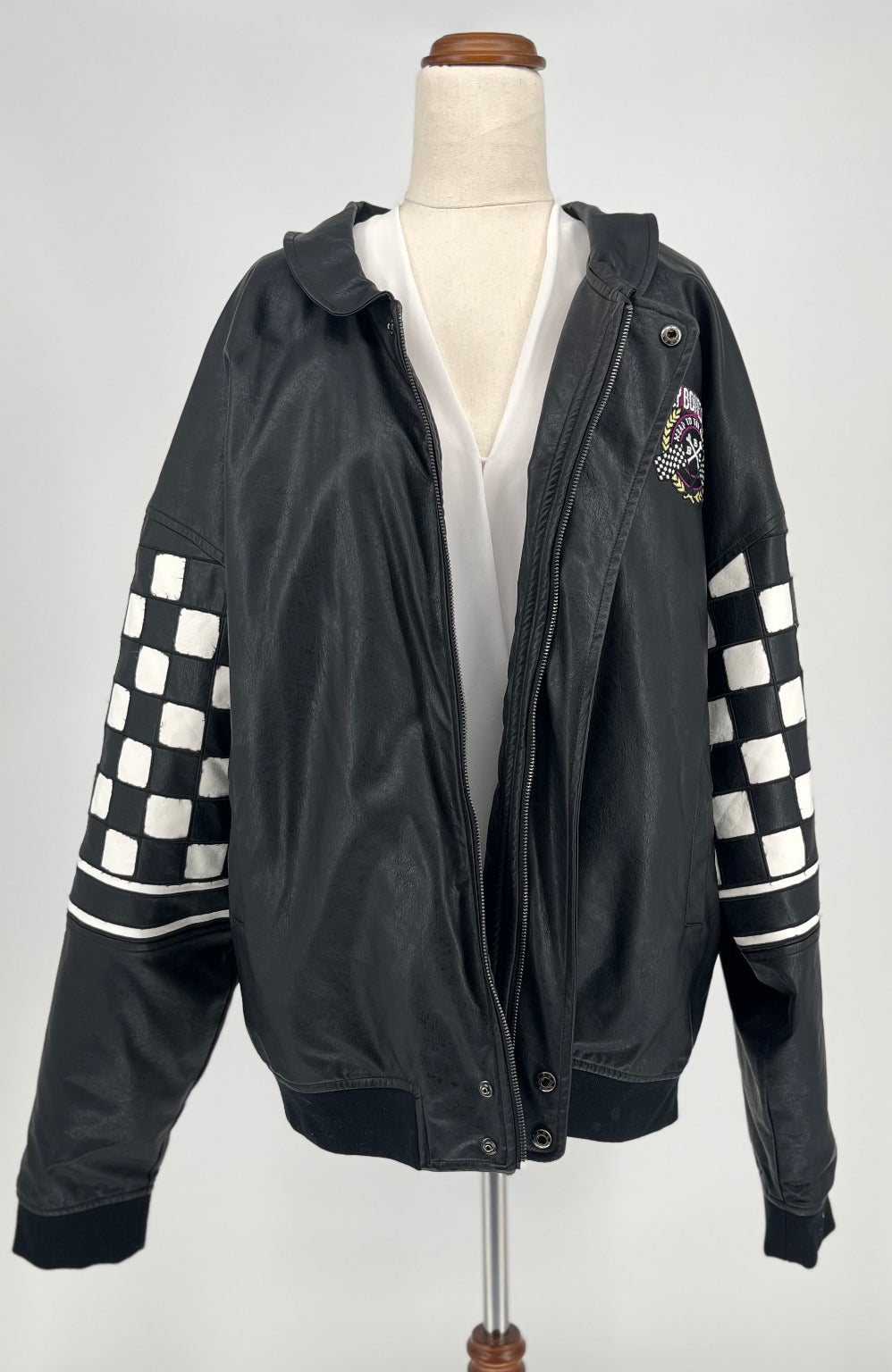 Black jacket with checkered sleeves on a mannequin against a white background