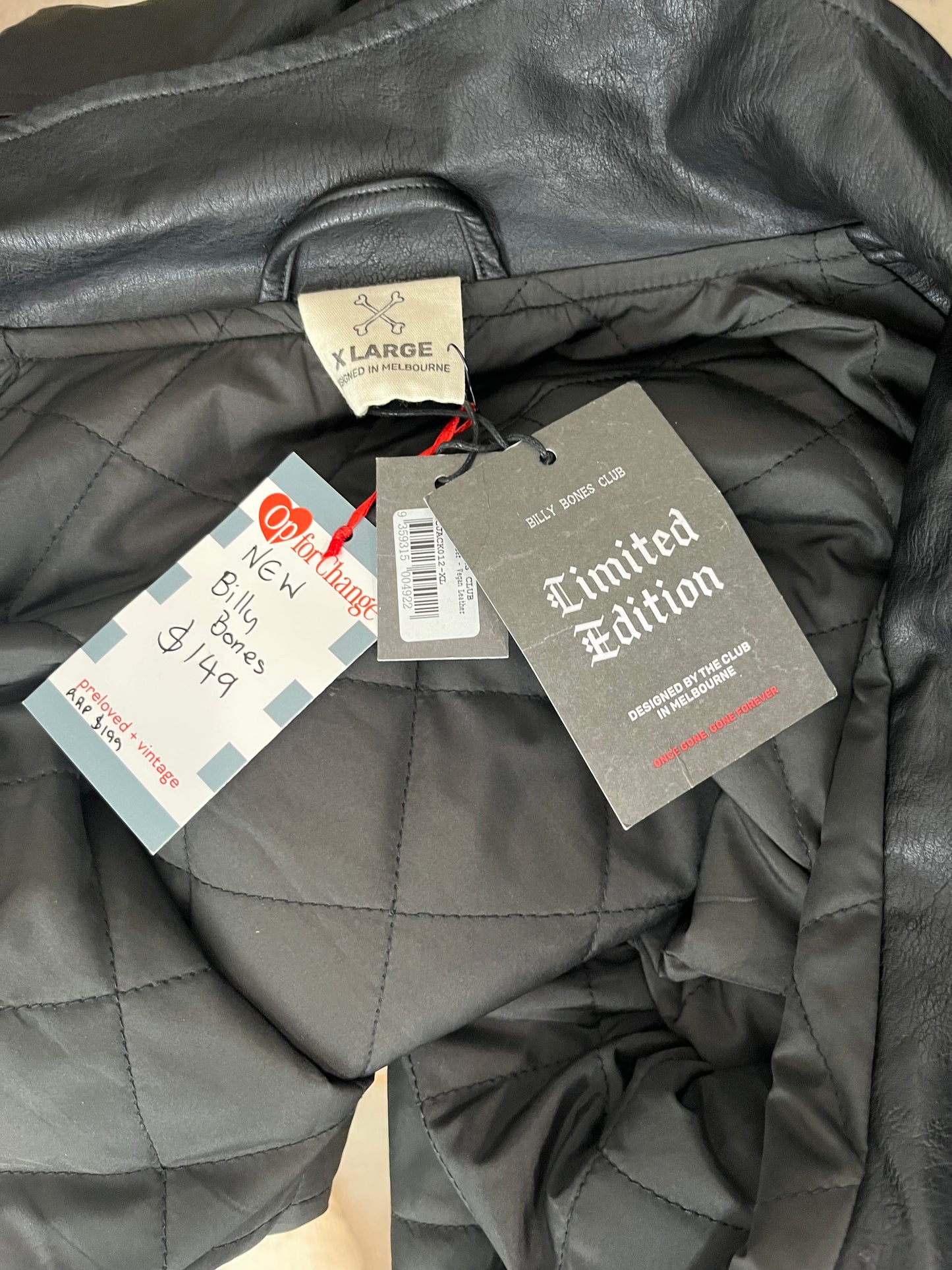 Gray quilted jacket with tags on a neutral background