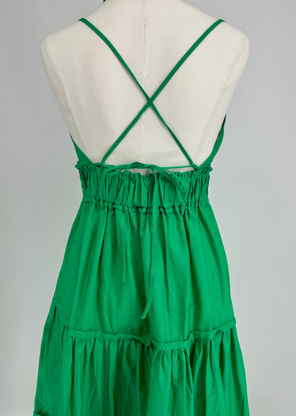 Green dress on a mannequin with a grey background