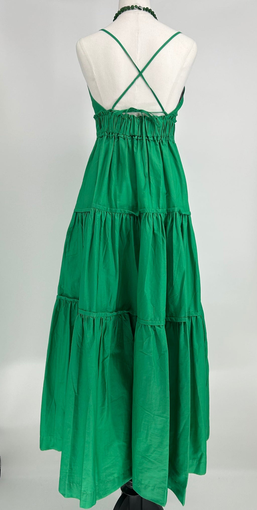 Green tiered dress on a mannequin against a white background