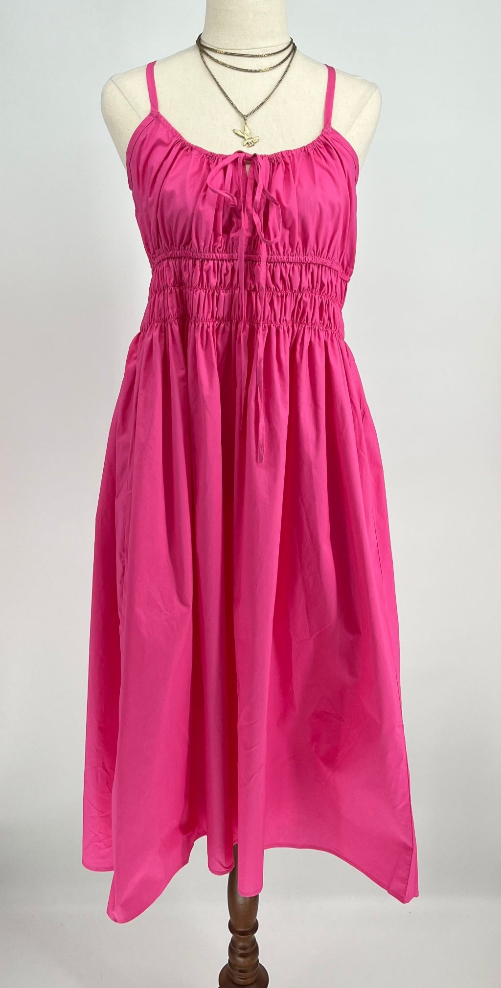 Pink dress on a mannequin against a white background