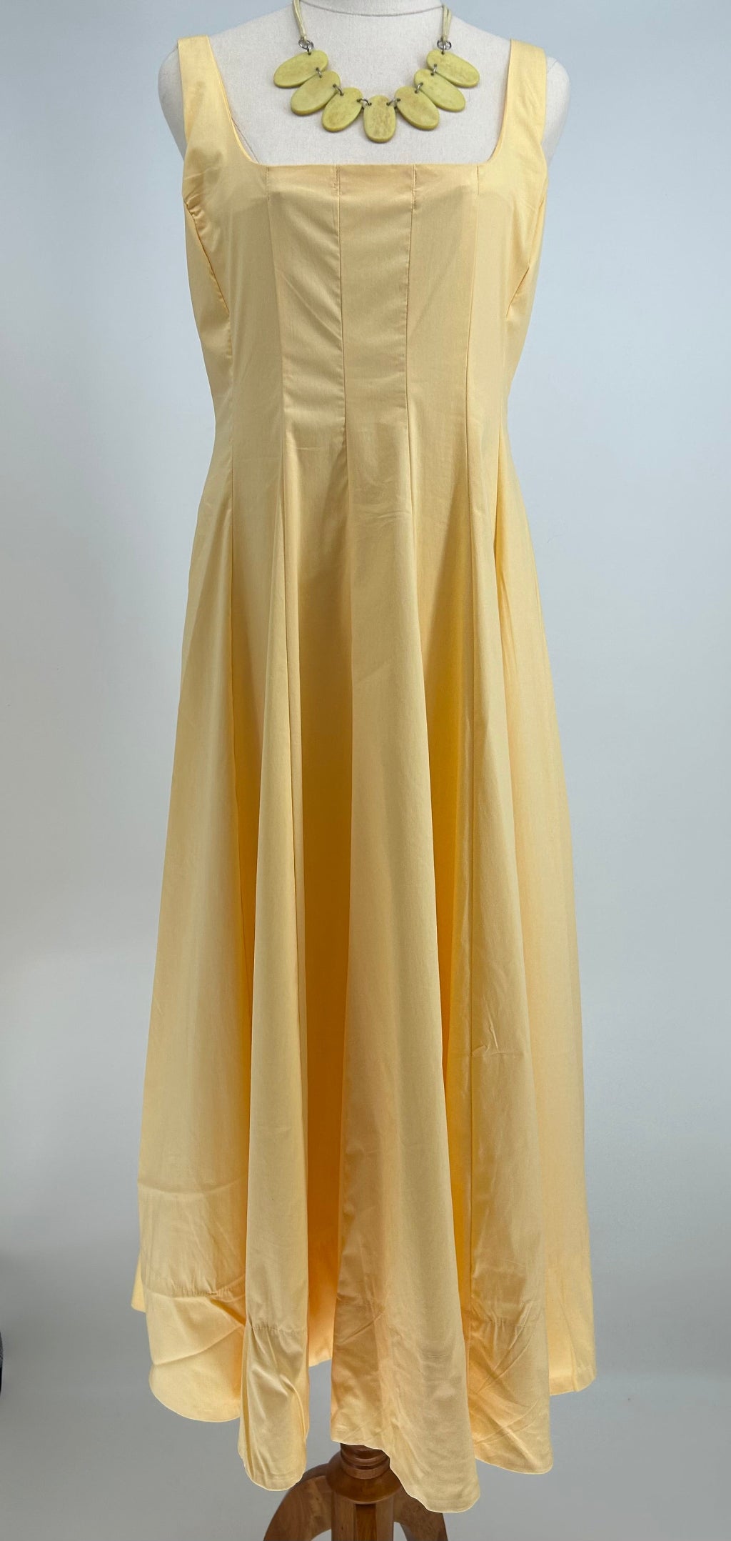 Yellow dress on a mannequin against a white background