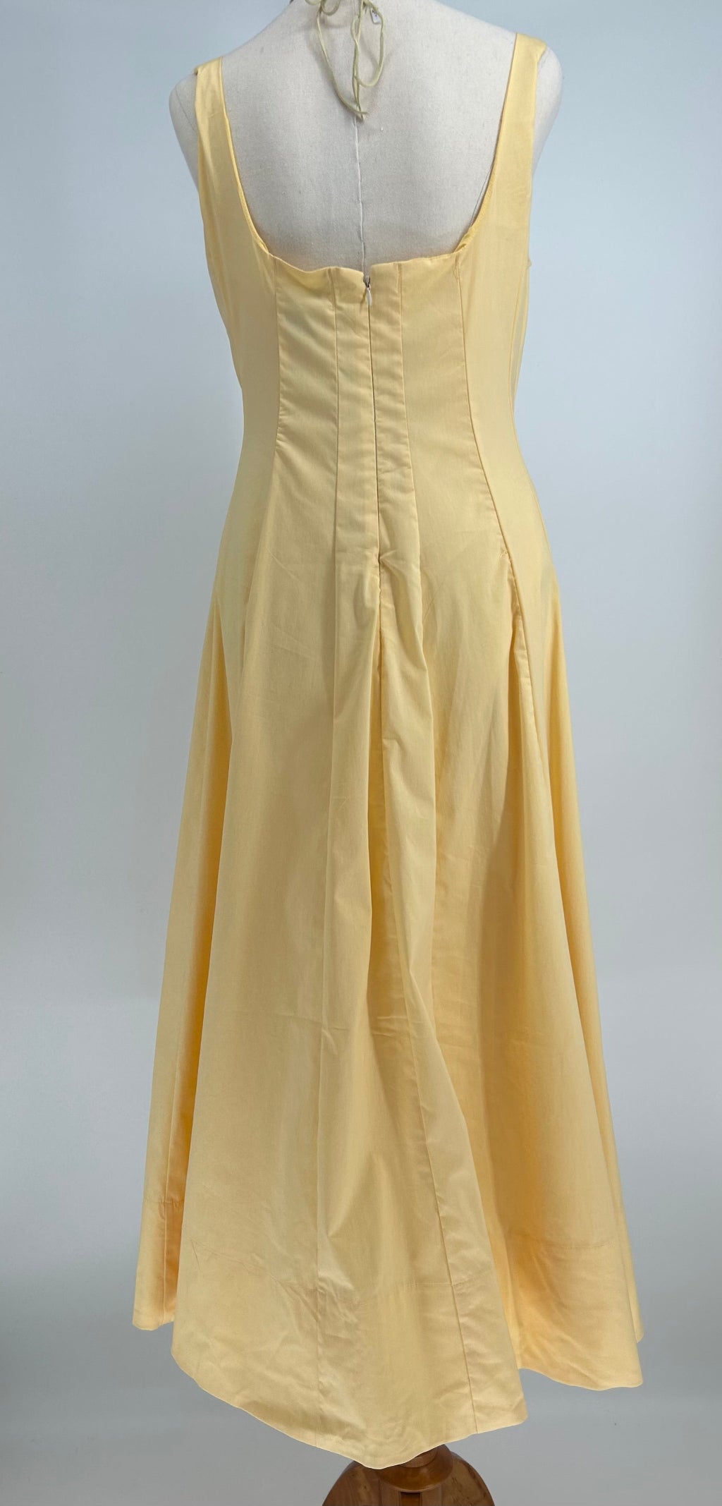 Yellow dress on a mannequin against a gray background