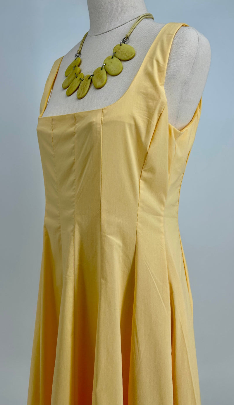 Yellow dress on a mannequin with a plain background