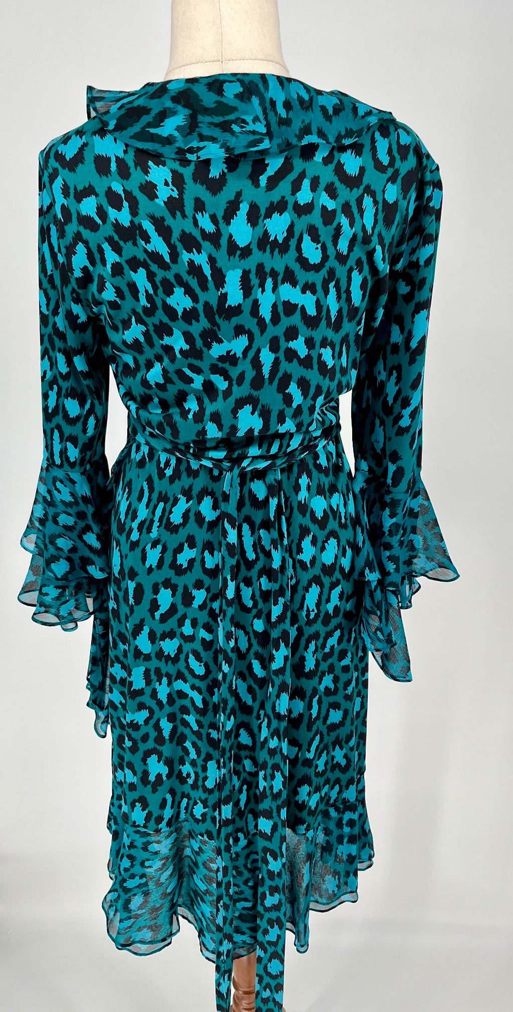 Teal leopard print dress on a mannequin against a white background