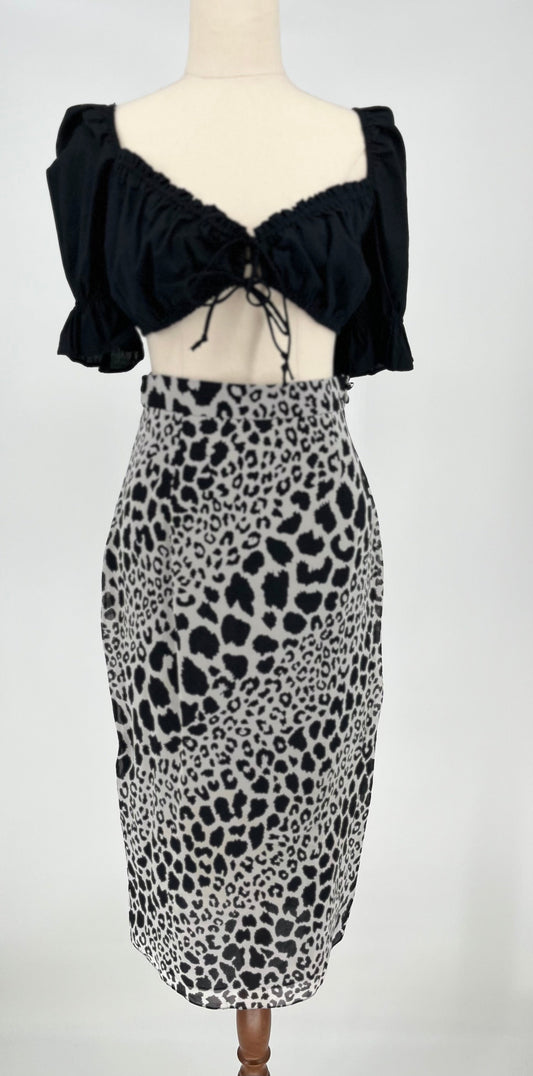 Mannequin wearing a black top and leopard print skirt on a white background