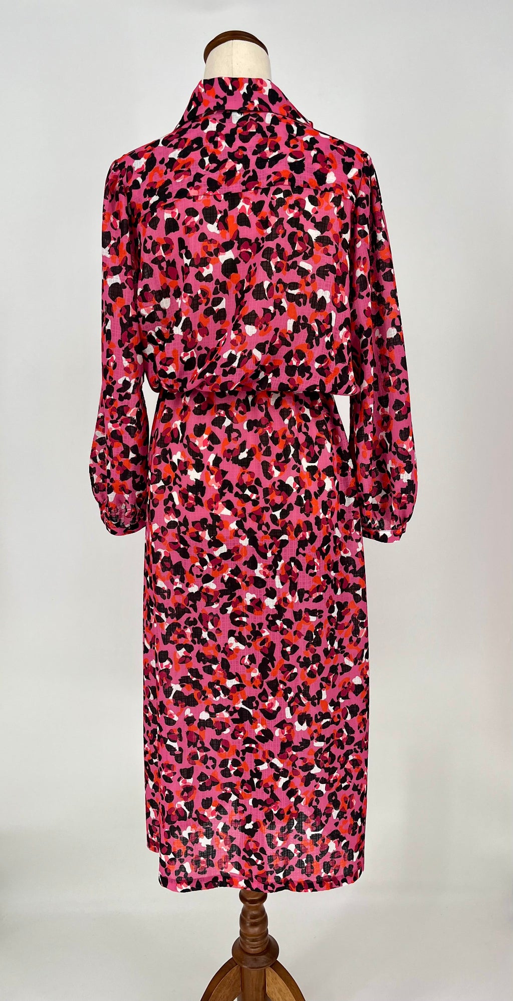 Pink leopard print dress on a mannequin against a white background