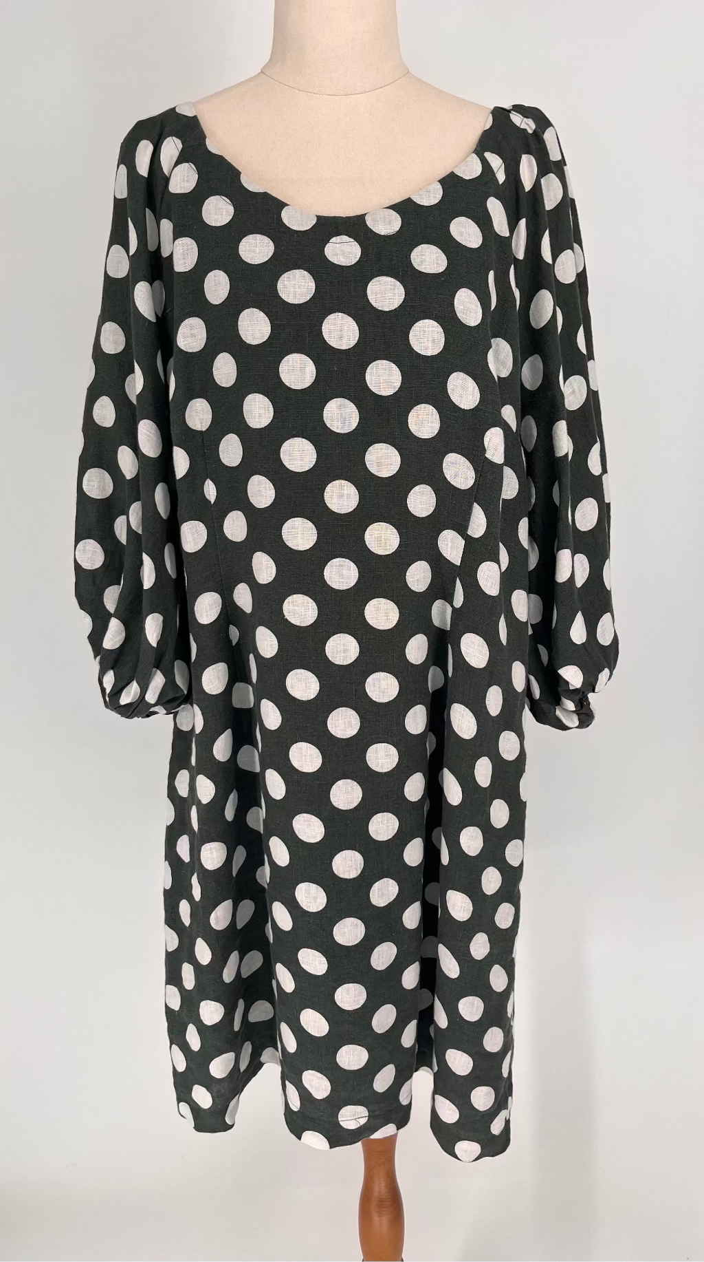  dress with white polka dots on a mannequin against a white background