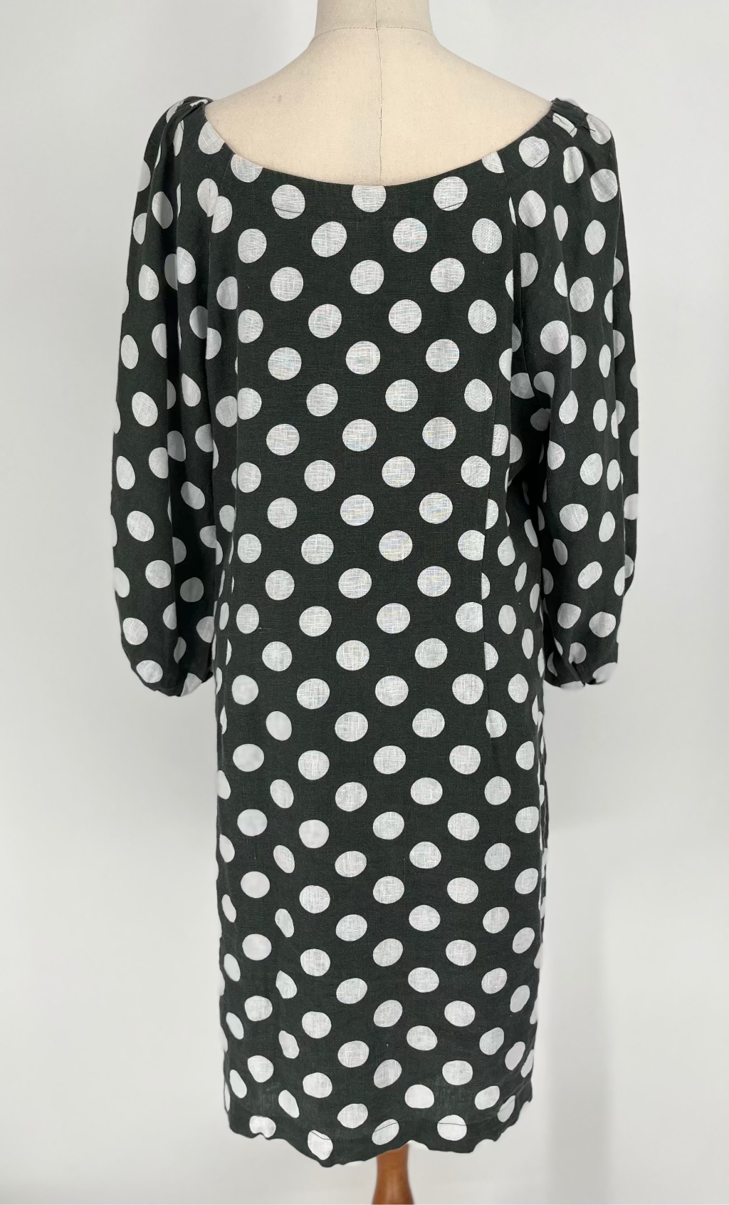  dress with white polka dots on a mannequin against a white background
