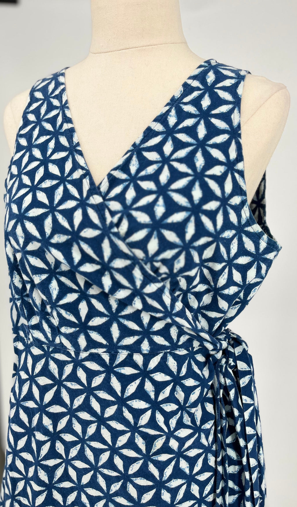 Blue and white patterned dress on a mannequin against a gray background