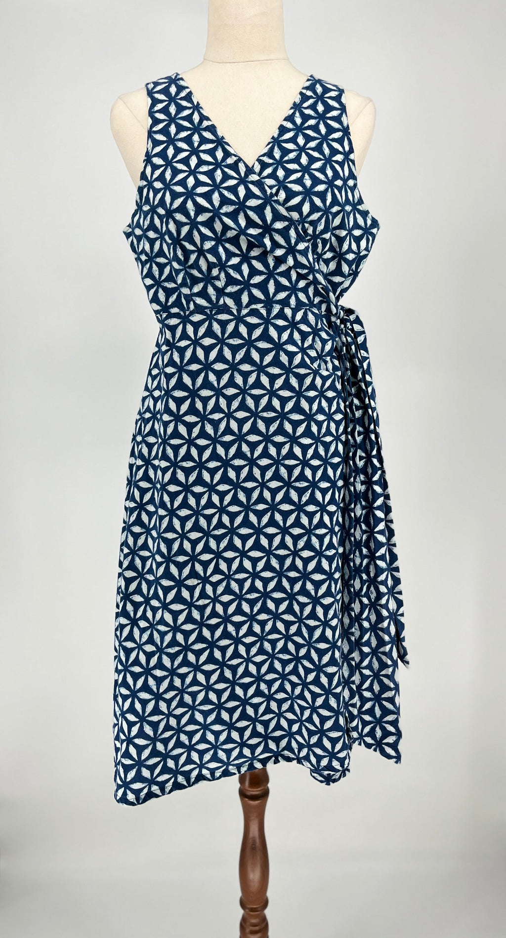 Blue geometric patterned dress on a mannequin against a white background