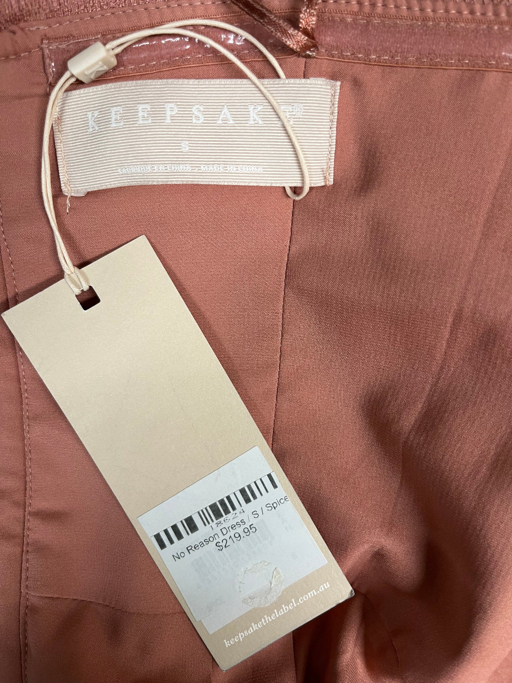 Close-up of a clothing tag on a brown fabric background