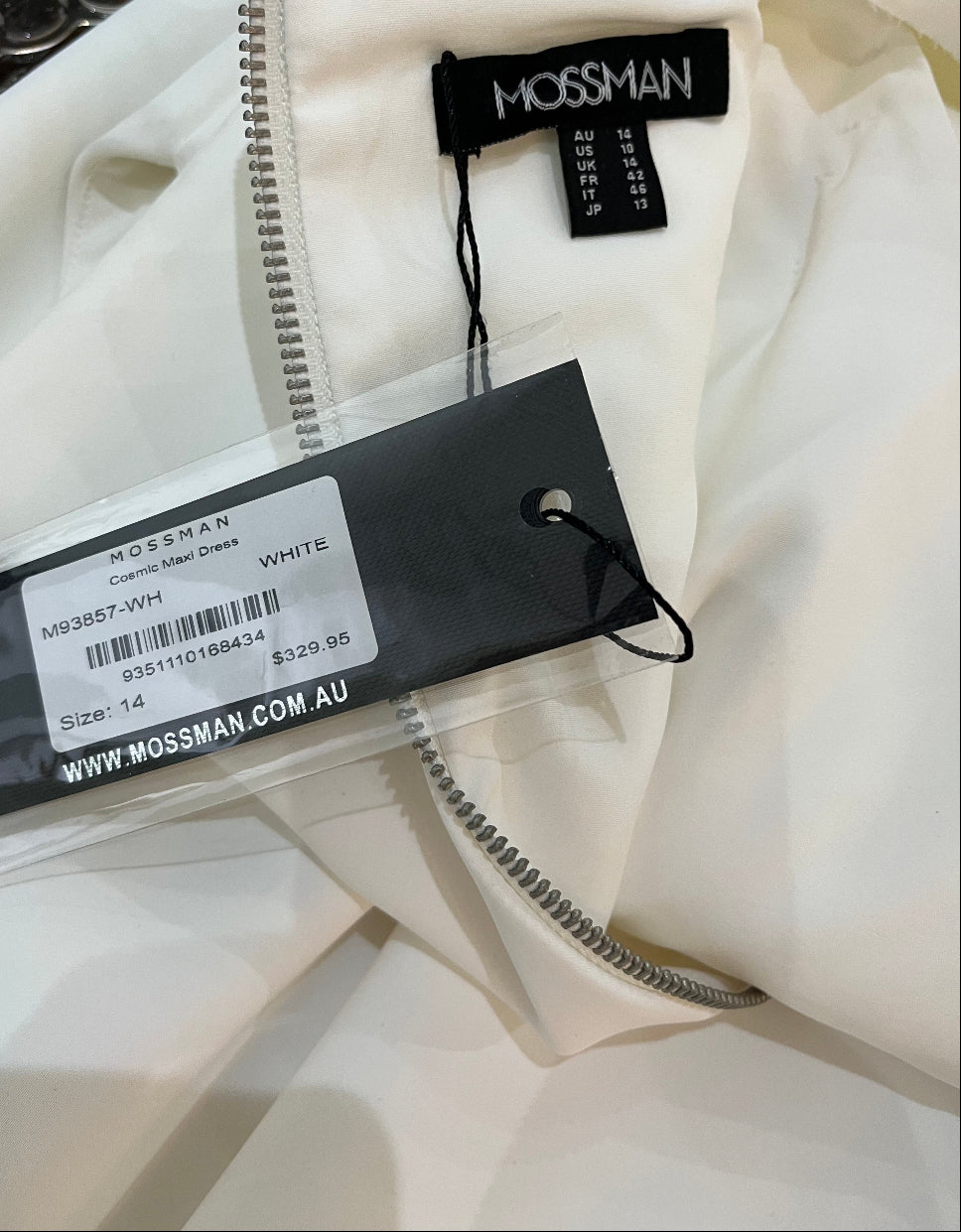 Close-up of a white jacket with Mossman branding on labels.