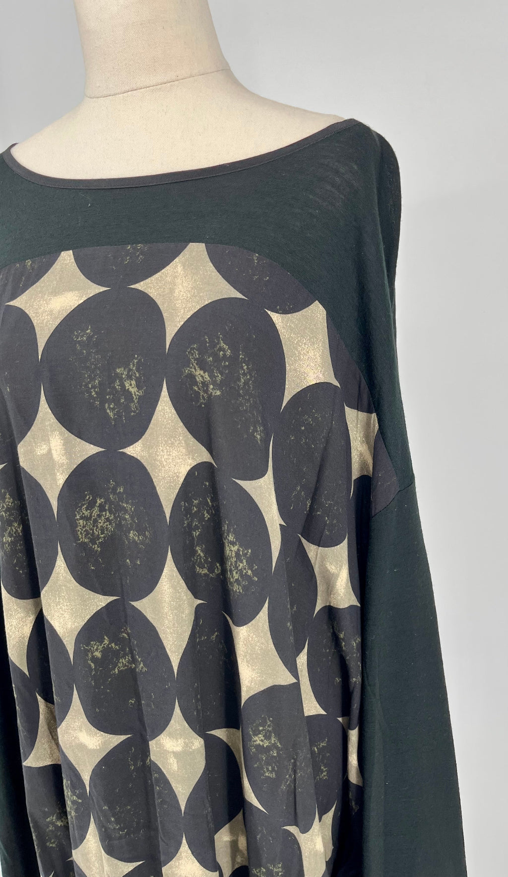 Black and gold patterned top on a mannequin against a white background