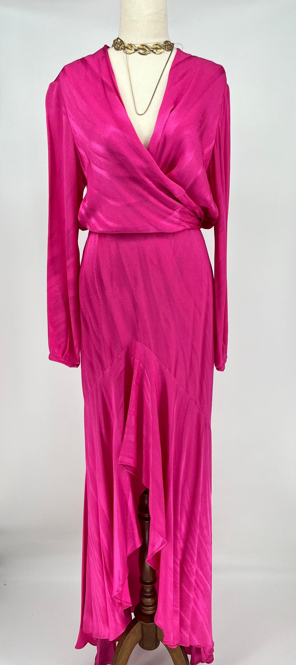 Fuchsia evening gown on a mannequin against a white background