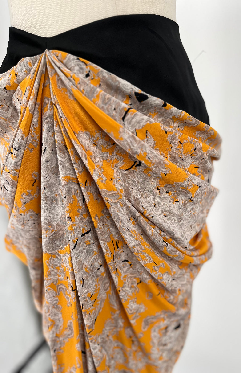 Mannequin wearing a yellow and gray patterned skirt  on a white background