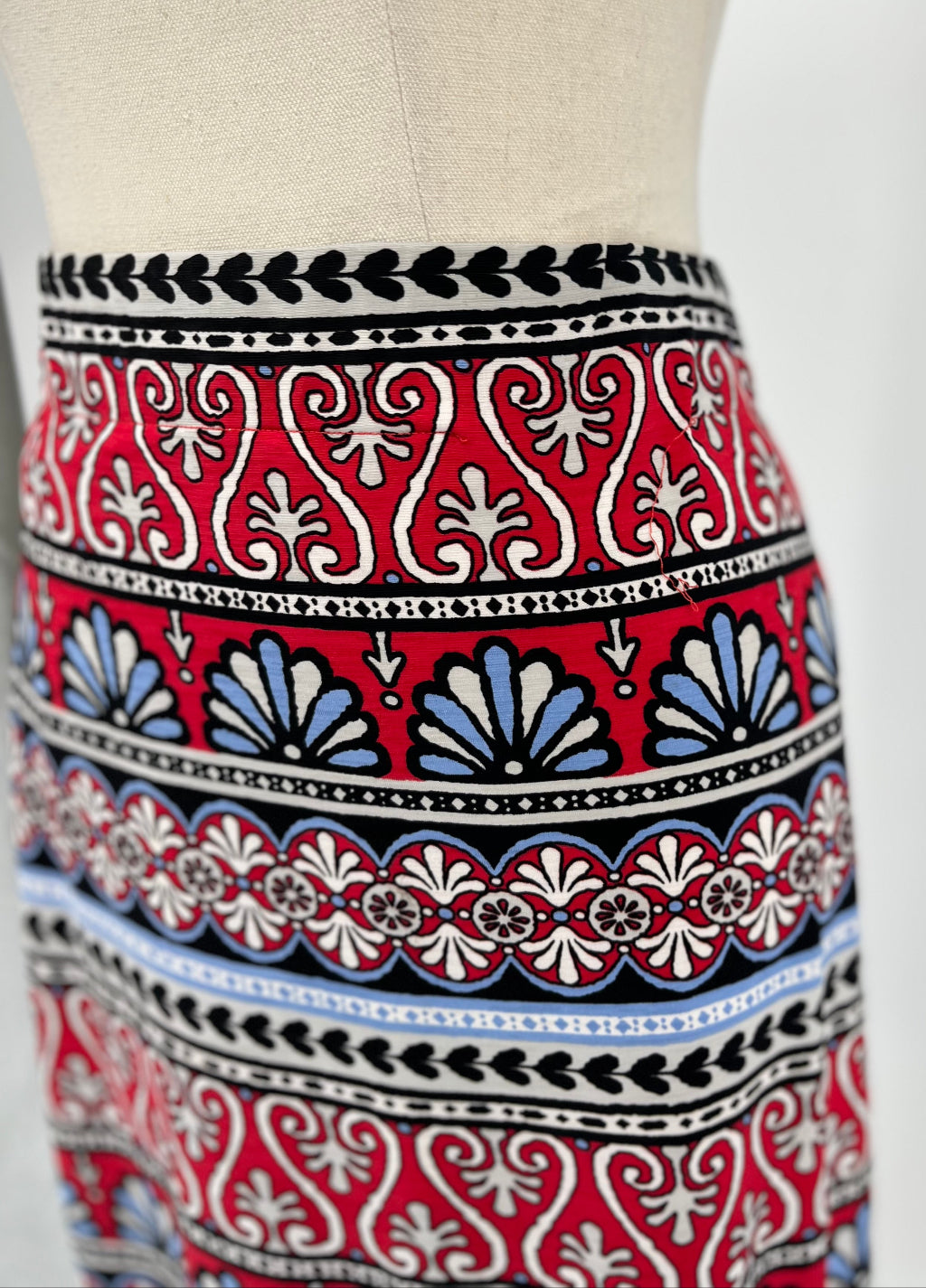 Skirt with a red, blue, and white pattern on a mannequin against a white background