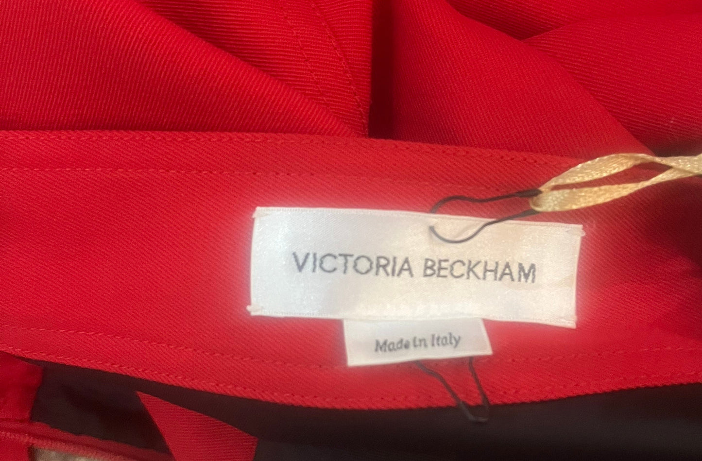 Red garment with a Victoria Beckham label on a blurred background