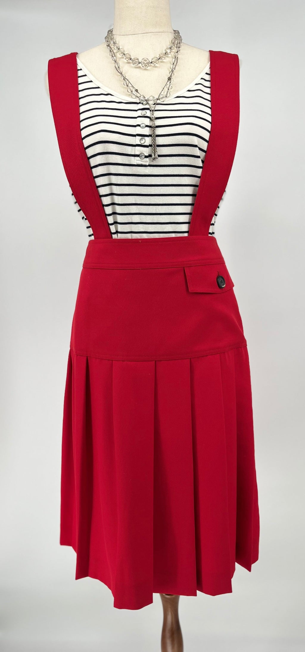 Red dress with black straps on a mannequin against a white background