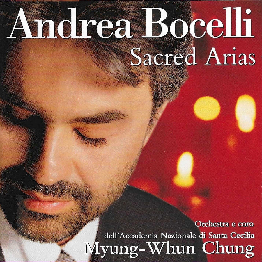 Sacred Arias album cover featuring Andrea Bocelli with a red background and blurred lights
