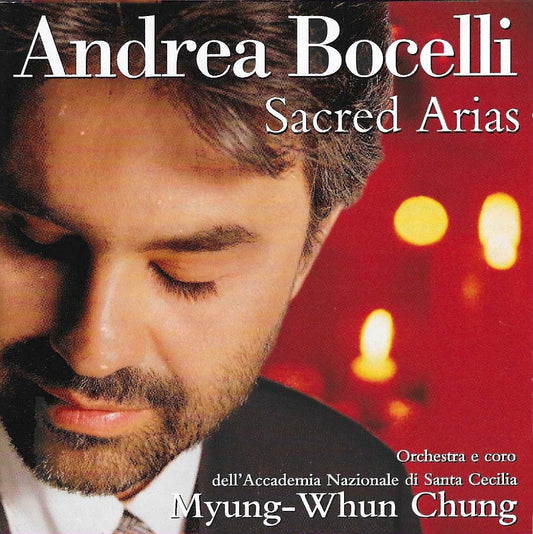 Sacred Arias album cover featuring Andrea Bocelli with a red background and blurred lights