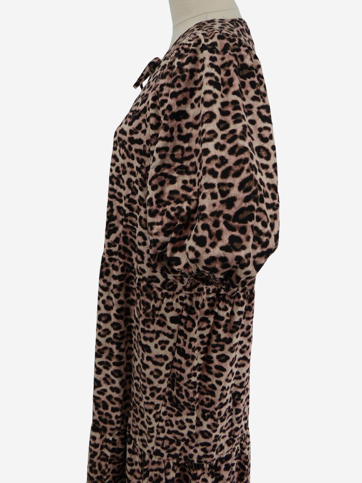 Side view of a Decjuba dress with an animal print, displayed on a mannequin 